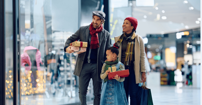 A family shopping during Black Friday, carrying gifts and shopping bags. This image highlights the significance of omnichannel marketing and MikMak insights in boosting Black Friday sales through shoppable media and where to buy solutions.