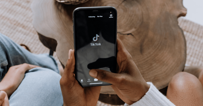 Person holding phone with TikTok app